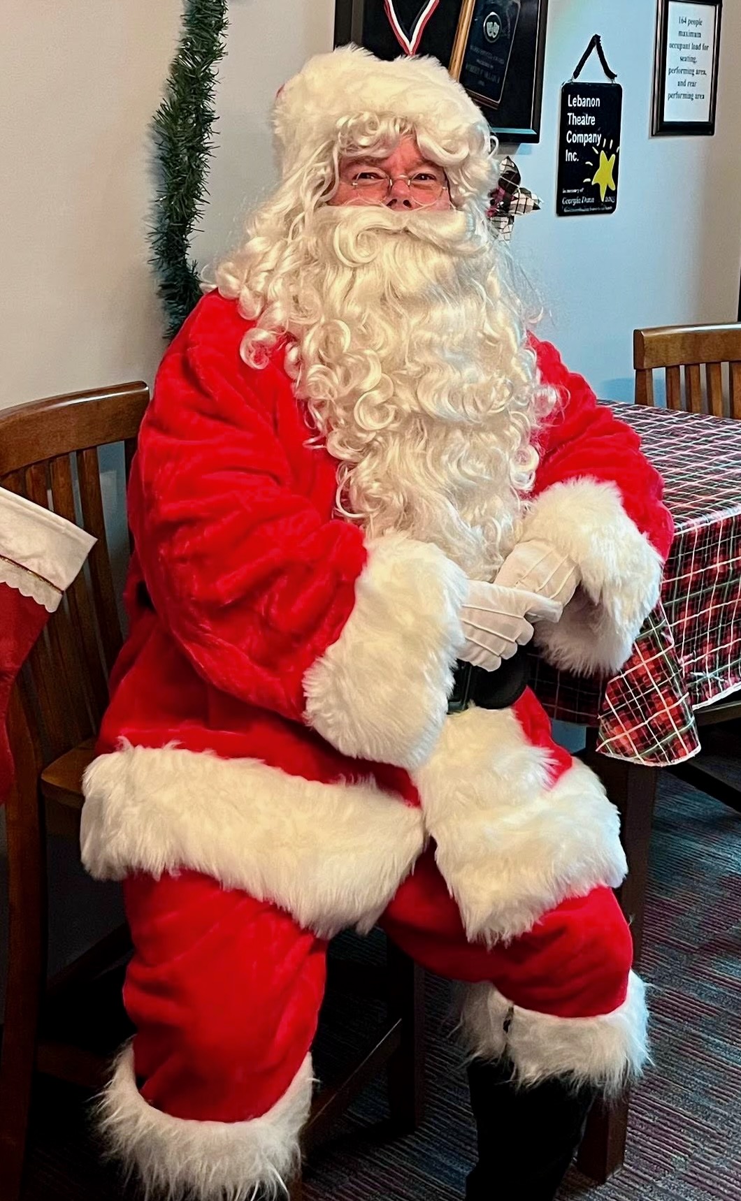 Santa Suscheck in full costume, seated and smiling for a portrait