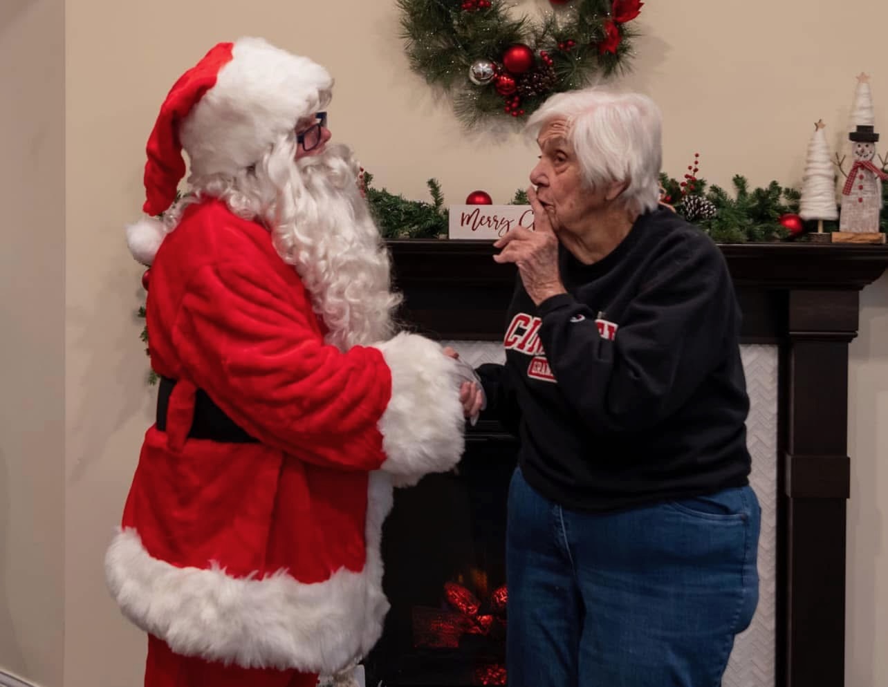 Santa Suscheck greeting a senior center resident during a holiday visit